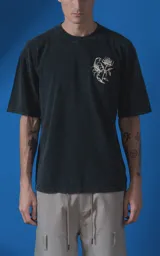 Remera de algodón premium con efecto nevado, corte oversize y cuello redondo. Presenta una estampa gráfica en la espalda con motivos de escorpión, rosa y tipografía en color crema.