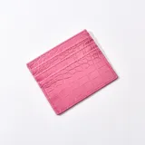 Tarjetero fucsia con textura símil cuero de cocodrilo y múltiples ranuras para tarjetas.