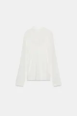 Camiseta blanca de manga larga con cuello alto y calce oversize. Incluye un top interior del mismo tejido.