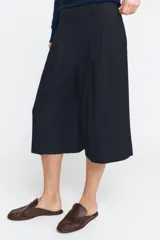 Bermuda de tiro medio con diseño de raya diplomática. Presenta cintura con trabillas, pinzas delanteras, bolsillos laterales y cierre frontal con cremallera, botón y ganchos metálicos.