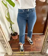 Jean azul de tiro alto y corte recto, con diseño cropped y terminación desmechada en el bajo.