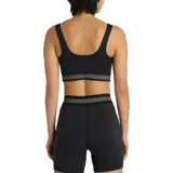 Top deportivo New Balance Train Bra, color negro con banda elástica inferior rayada en blanco y logo de la marca en el centro.
