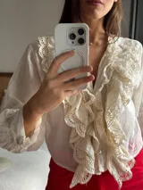 Camisa verde de manga larga, con volados frontales y detalles de puntilla bordada.