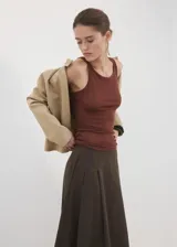 Falda midi evasé de tiro medio, color marrón oscuro, con diseño cruzado frontal y cierre de cremallera en la parte posterior, cuenta con forro interior.