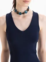 Top negro de tejido frío, ajustado al cuerpo y largo por debajo de la cintura.