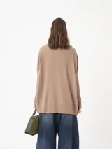 Sweater azul con cuello alto y puños de piel sintética color rosa.