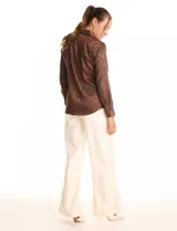 Camisa de satén labrado color marrón con estampado animal print tonal. Presenta cuello con solapa, manga larga y cierre frontal con botones.