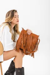 Cartera bandolera color suela, con diseño de flecos largos en la parte frontal y correa ajustable.