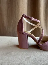 Zapatos de tacón bajo en tela color malva, con punta fina, taco ancho de 5 cm, escote en V y tiras cruzadas en diagonal con cierre de hebilla en el tobillo.