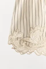 Shorts de tiro medio y cintura elástica, confeccionados en mezcla de algodón y viscosa con diseño de rayas verticales. Presenta el bajo acabado con aplicación de encaje y bordados en contraste.