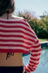 Jersey corto de punto con cuello redondo y diseño de rayas horizontales en tonos rosados y rojos, de manga larga.
