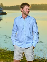 Camisa de vestir de hombre a cuadros celestes y blancos, de corte clásico, con cuello italiano y logo bordado en el frente.