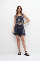 Short azul marino con bordado floral blanco, tiro alto y cinturón de lazo.