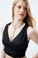 Top cropped negro con capucha, escote cruzado y calce ceñido.