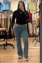 Jean de corte oxford con tiro alto, confeccionado en denim azul con efecto localizado. Presenta cierre frontal con botón y bolsillos laterales y traseros.
