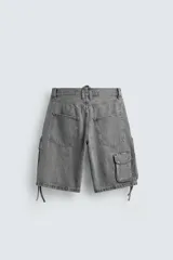 Bermuda de corte relajado en denim de algodón color beige, estilo cargo, con cinco bolsillos y bolsillos plastrón con solapa en las perneras.