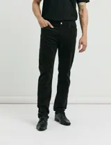 Pantalon de pana de corte recto con diseño de cinco bolsillos, incluyendo bolsillos traseros de parche y cierre con botones y remaches metálicos.