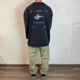 Buzo oversize de color negro con estampado gráfico en la espalda que incluye un diseño de caracol y texto descriptivo.