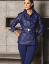 Chaqueta azul de cuero sintético con cuello clásico, cierre frontal con botones, cinturón con hebilla metálica, bolsillos con solapa y mangas largas con botones en los puños.