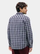 Camisa de manga larga con estampado de cuadros en tonos azul marino y blanco, con cuello clásico y cierre frontal de botones.