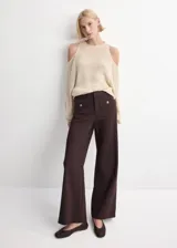 Pantalón de vestir marrón oscuro, de tiro medio y corte recto, con bolsillos frontales tipo parche decorados con botones metálicos dorados.
