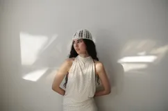 Vestido corto blanco con lunares negros, cuello halter y espalda descubierta.