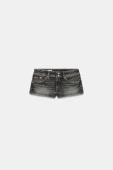 Shorts de jean tiro bajo con diseño de cinco bolsillos y efecto desteñido. Cierre frontal con cremallera y dos botones metálicos.