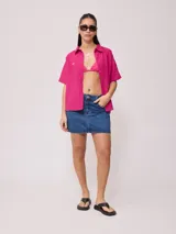 Camisa color verde lima, de manga corta, con bolsillo en el pecho y cierre con botones.