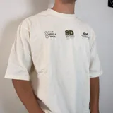 Remera de corte oversize color blanco con estampado gráfico en la espalda en color verde oliva que incluye el texto 'SOFT DISORDER' y detalles de marca.