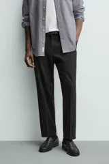 Pantalón de vestir regular fit color negro, confeccionado en tejido con mezcla de lana y elasticidad. Cuenta con cintura elástica, bolsillos frontales, bolsillos traseros de vivo con botón, y cierre frontal con cremallera y botón.