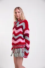 Sweater tejido a crochet de lana merino con diseño de rayas en zigzag de colores, cuello redondo, mangas largas amplias y calce holgado.