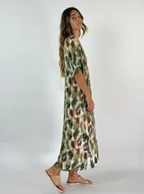 Vestido largo con estampado animal print en tonos marrones y blancos, con cuello en V y mangas cortas con ribete blanco.