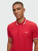 Remera polo de algodón color gris oscuro, marca Boss, modelo Paddy. Corte regular fit, cuello y puños con ribete doble en blanco y gris. Logo bordado en el pecho.