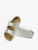 Sandalias Birkenstock Arizona color blanco, con doble tira ajustable con hebilla metálica y plantilla anatómica de corcho y látex.