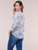 Blusa Hope & Harlow de gasa estampada con patrón floral en tonos azul y blanco, escote en V con botones frontales, mangas largas regulables y nudo decorativo en el ruedo.
