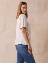 Blusa color crema de crepe con detalle de crochet en el escote, mangas cortas amplias.