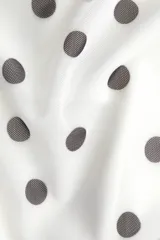 Top entallado de malla transparente color blanco con lunares negros. Presenta un escote asimétrico, un solo bretel y tiras anchas que se atan al cuello. Incluye forro de punto.