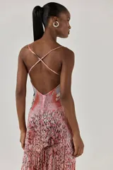 Vestido largo ajustado de tul, con diseño de mariposa bordado en cuentas en el busto, abertura frontal, tirantes finos y falda con flecos de cuentas en degradado de tonos rojizos.