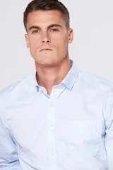 Camisa celeste lisa de vestir, con cuello clásico, manga larga, bolsillo en el pecho y corte regular.