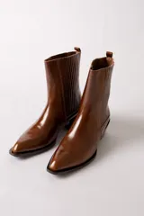 Bota de cuero negro estilo texano, con caña media, elástico lateral con costuras verticales y taco cuadrado.