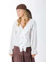 Blusa color blanco confeccionada en bambula liviana, con textura suave y caída fluida, escote en V con volados y mangas largas con puños elásticos.