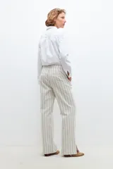 Pantalón de vestir color beige con rayas verticales negras, de corte recto y tiro alto.
