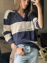 Sweater de punto con cuello polo y botones, a rayas horizontales color marrón y beige.