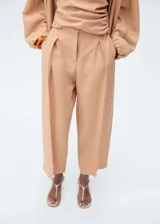 Pantalón de tiro medio con diseño recto y largo, confeccionado en tejido de lyocell. Presenta cierre delantero con botón, gancho y cremallera ocultos, trabillas en la cintura y detalle de pinzas frontales. Incluye dos bolsillos laterales.