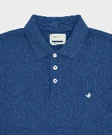 Remera polo verde militar de algodón pima, con cuello y puños acanalados, cierre frontal de tres botones y pequeño bordado de ave en el pecho.