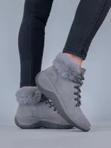 Botas de estilo montañés color gris, confeccionadas en cuero y poliéster. Presentan cuello con forro de piel sintética, ajuste mediante cordones con ganchos metálicos y suela de goma con tecnología Spinal Flex para mayor confort.
