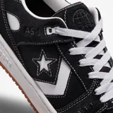 Championes Converse modelo AS-1 Pro, color negro con detalles en blanco. Presentan capellada de gamuza con costuras visibles, el icónico logo de estrella y chevrón en el lateral, cordones blancos y suela de goma color caramelo.