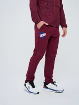 Pantalón de entrenamiento Umbro del Club Nacional de Football, modelo Grok en color azul. Presenta el escudo del club en una pierna y el logo de Umbro en la otra, con diseño cómodo y deportivo.