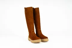 Bota de caña alta confeccionada en cuero nobuck color marrón, con suela track dentada y detalle de tirador en la parte superior de la caña.