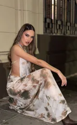 Vestido largo de microtul con estampado tie-dye en tonos beige y marrón, escote halter con espalda descubierta y falda con transparencia.